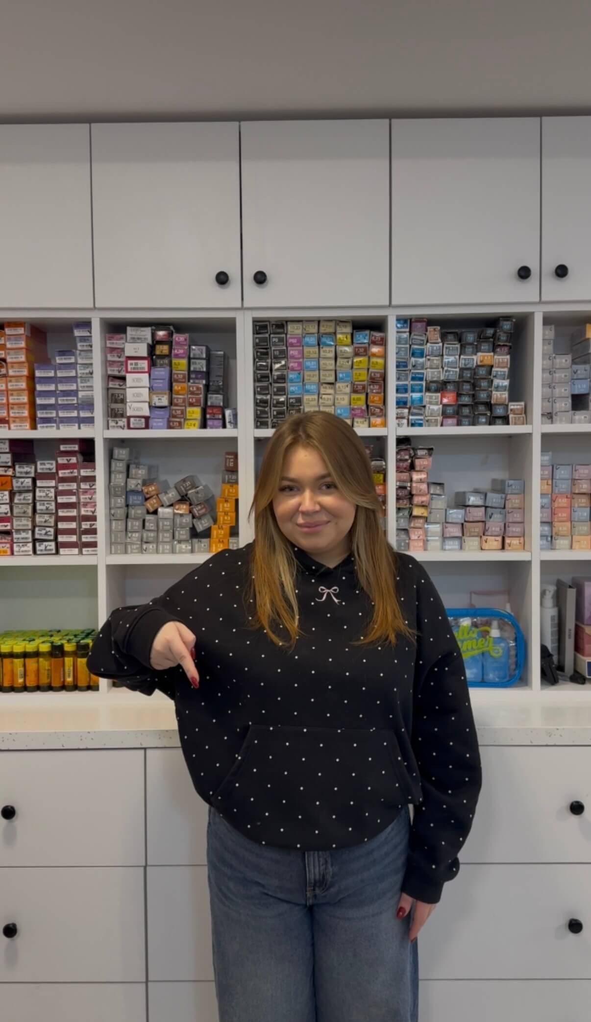 Olga wskazuje w dół na listę usług salonu